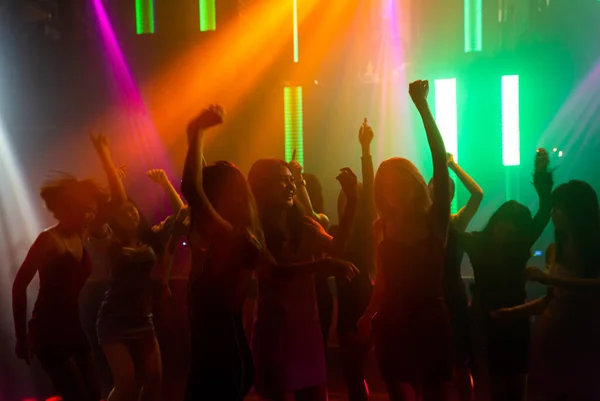 Силуэт изображения людей танцуют в дискотеке ночной клуб под музыку от DJ на сцене — стоковое фото