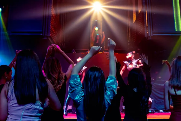 Grupo de personas bailan en discoteca al ritmo de la música de DJ en el escenario — Foto de Stock