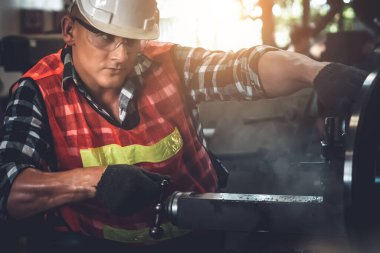 Akıllı fabrika işçisi veya mühendisi bir imalat atölyesinde makine işi yapıyor.