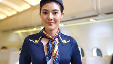 Kabin görevlisi ya da hostes uçakta çalışıyor.