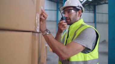 Profesyonel kargo işçisi başka bir işçiyle bağlantı kurmak için telsizle konuşuyor.
