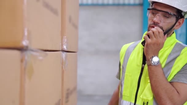 Professionell lastarbetare talar på bärbar radio för att kontakta en annan arbetstagare — Stockvideo