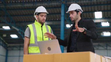 Fabrikada çalışan ve üretim planını tartışan iki fabrika işçisi. .