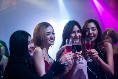 Gençler parti veriyor, içiyor ve dans ediyor.