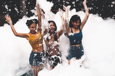 Eğlence ve neşeyle kabarcık havuzunda oynayan kız