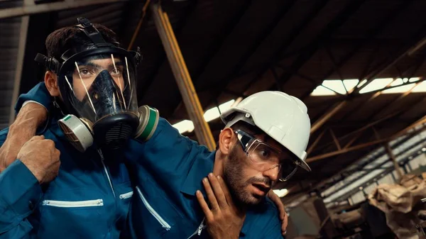 Umiejętny pracownik fabryki ratuje kolegę z drużyny przed wyciekiem trującego gazu. — Zdjęcie stockowe