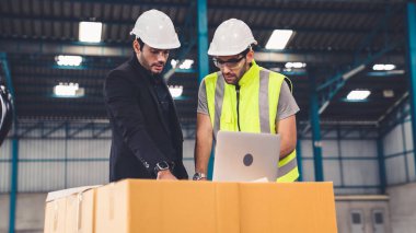 Fabrikada çalışan ve üretim planını tartışan iki fabrika işçisi. .
