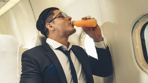 Бізнесмен має апельсиновий сік, який подає повітряна господиня в літаку — стокове фото
