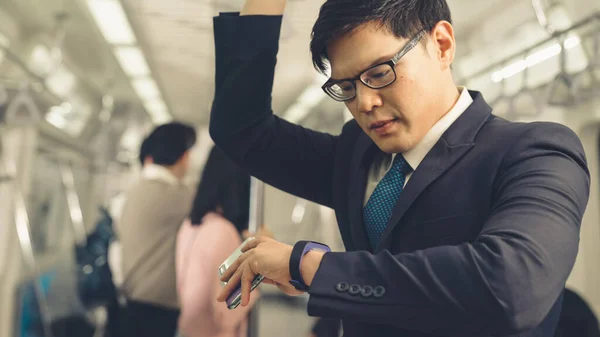 Empresário que utiliza telemóvel no comboio público — Fotografia de Stock