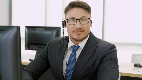 オフィスで働くヘッドセットを身に着けているビジネスマン — ストック写真