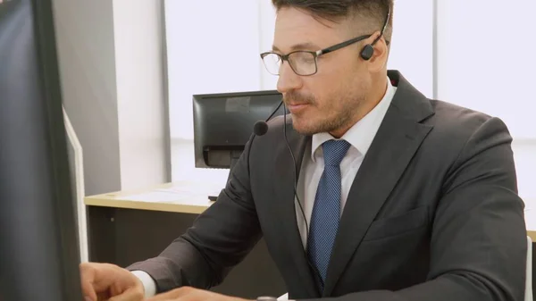 Επιχειρηματίες που φορούν ακουστικά και εργάζονται στο γραφείο — Φωτογραφία Αρχείου