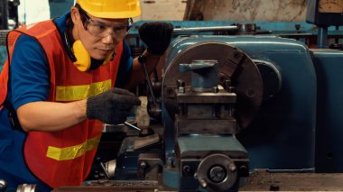 Fabrika işçisi veya mühendisi imalat atölyesinde makine işi yapıyor.