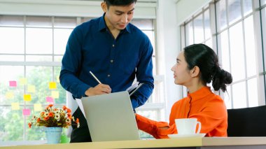 İki iş adamı ofiste proje stratejisi hakkında konuşuyor