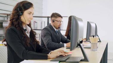 Ofiste çalışan kulaklık takan iş adamları.