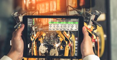 Mühendis, artırılmış gerçeklik endüstrisi teknolojisiyle robotik kolları kontrol ediyor.
