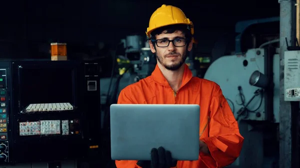 Travailleur d'usine compétent travaillant avec un ordinateur portable pour faire la liste de vérification de la procédure . — Photo