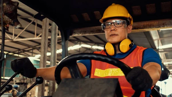 Un travailleur habile conduit un chariot élévateur à fourche dans l'usine . — Photo