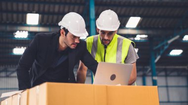 Fabrikada çalışan ve üretim planını tartışan iki fabrika işçisi. .