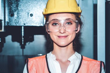 Genç kadın fabrika işçisi imalat fabrikasında portre kapatılıyor.