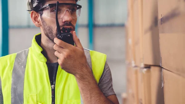 Professionell lastarbetare talar på bärbar radio för att kontakta en annan arbetstagare — Stockfoto