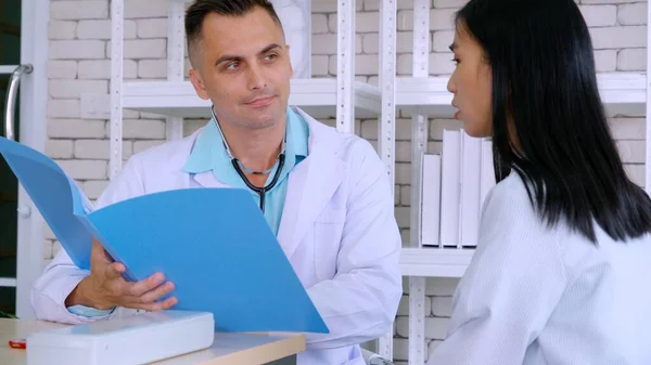 Doutor em uniforme profissional examinando paciente no hospital — Fotografia de Stock