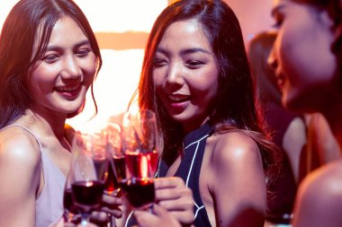 Gençler parti veriyor, içiyor ve dans ediyor.