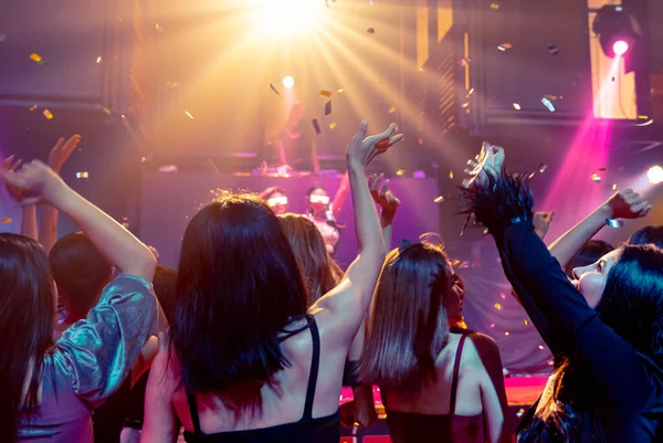 Grupo de personas bailan en discoteca al ritmo de la música de DJ en el escenario — Foto de Stock