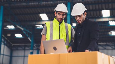 Fabrikada çalışan ve üretim planını tartışan iki fabrika işçisi. .