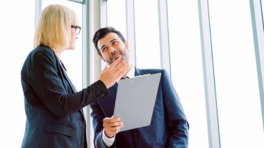 İki iş adamı ofiste proje stratejisi hakkında konuşuyor