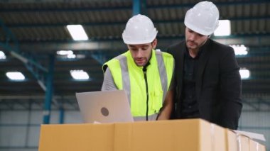 Fabrikada çalışan ve üretim planını tartışan iki fabrika işçisi. .