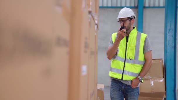 Professionell lastarbetare talar på bärbar radio för att kontakta en annan arbetstagare — Stockvideo