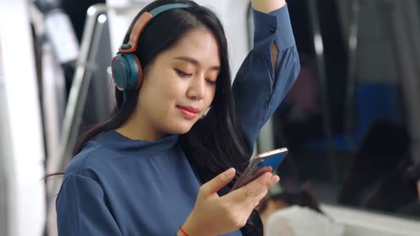 Young woman using mobile phone on public train — Stock Video