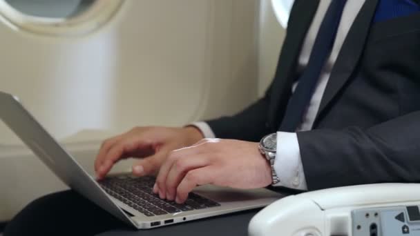 Jeune homme d'affaires utilisant un ordinateur portable dans l'avion — Video