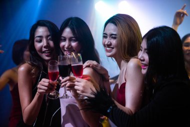 Gençler parti veriyor, içiyor ve dans ediyor.