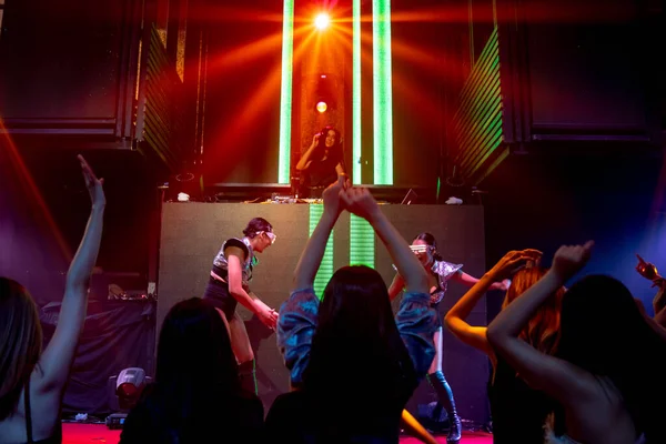 Gruppo di persone danza in discoteca night club al ritmo di musica da DJ sul palco — Foto Stock