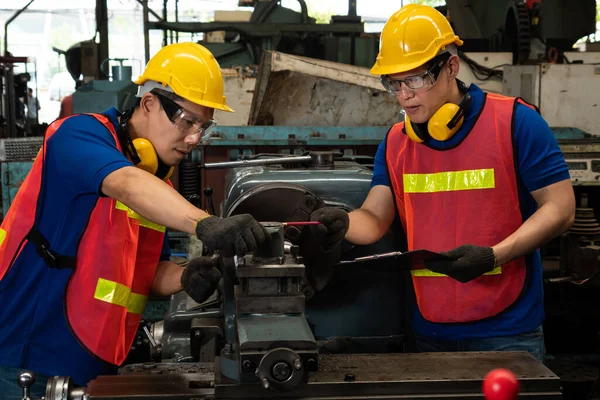 ワークショップで機械設備を使用した熟練した工場労働者のグループ — ストック写真