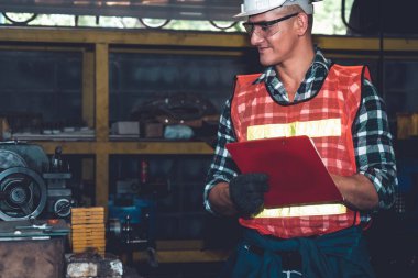 Akıllı fabrika işçisi veya mühendisi bir imalat atölyesinde makine işi yapıyor.