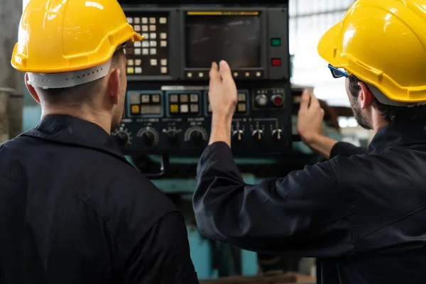 Groep bekwame fabrieksarbeiders die machineapparatuur gebruiken in de werkplaats — Stockfoto