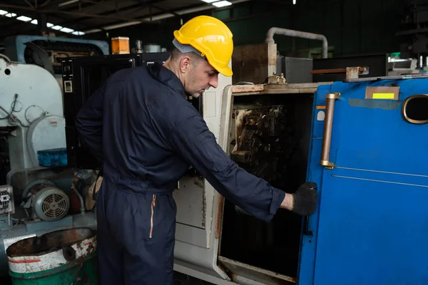 Fabrika mühendisi veya işçisi üretim atölyesinde makine işi yapıyor. — Stok fotoğraf