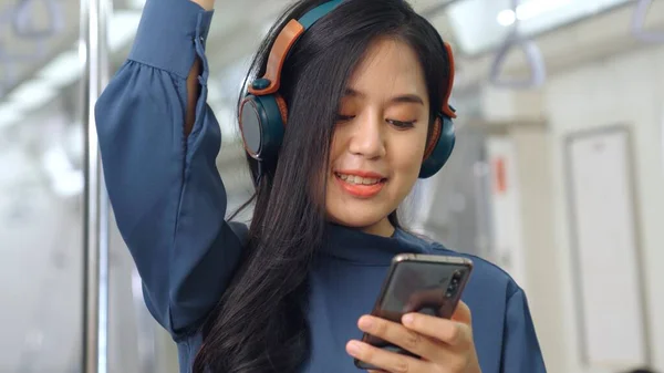 Jeune femme utilisant un téléphone portable dans le train public — Photo