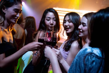 Gençler parti veriyor, içiyor ve dans ediyor.