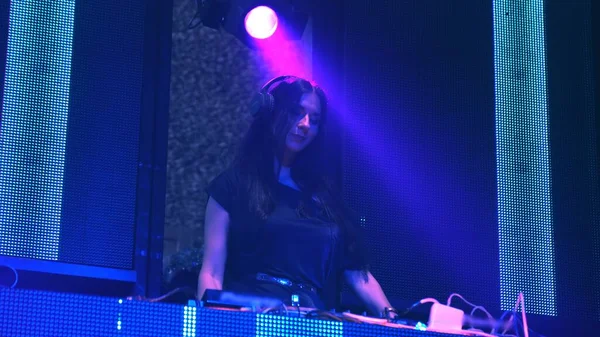 DJ op het podium in disco nachtclub mengen techno muziek beat — Stockfoto