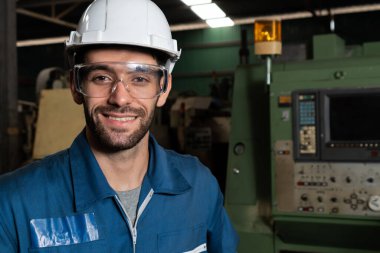 Genç yetenekli fabrika işçisi ya da mühendis fabrikada portre yakın plan