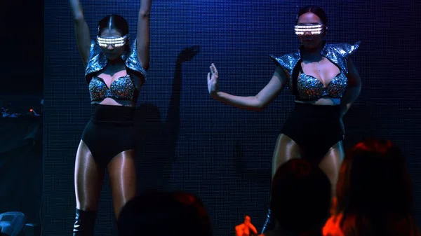 Grupo de personas bailan en discoteca al ritmo de la música de DJ en el escenario — Foto de Stock