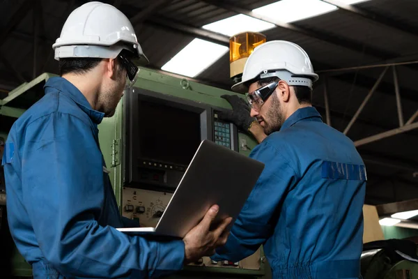 Gruppo di operai qualificati che utilizzano attrezzature per macchine in officina — Foto Stock