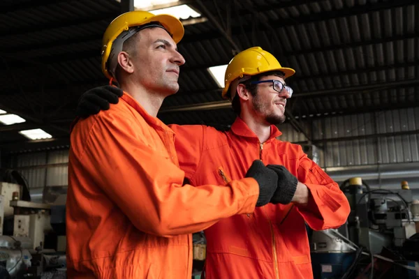 Dos hábiles ingenieros de fábrica o trabajadores que muestran trabajo en equipo y asociación . — Foto de Stock