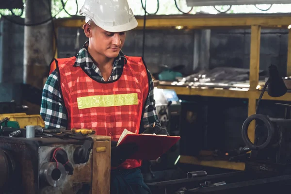 Trabalhador de fabricação que trabalha com área de transferência para fazer a lista de verificação do procedimento de trabalho . — Fotografia de Stock