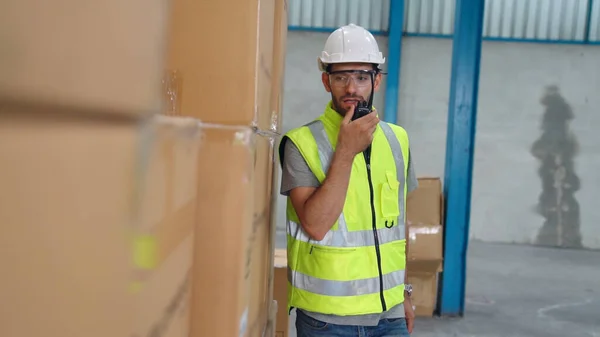 Professionell lastarbetare talar på bärbar radio för att kontakta en annan arbetstagare — Stockfoto