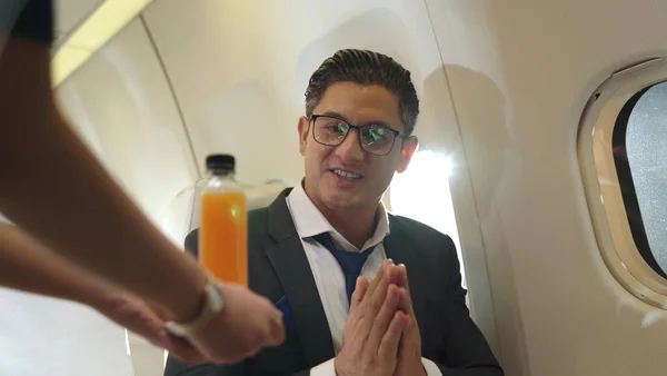 Empresário tem suco de laranja servido por uma aeromoça em avião — Fotografia de Stock