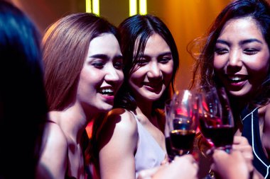 Gençler parti veriyor, içiyor ve dans ediyor.